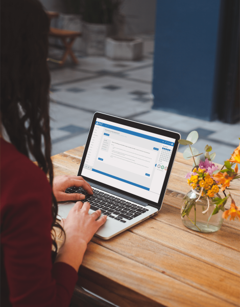 mockup-of-a-woman-using-a-macbook-pro-on-a-wooden-table-with-some-flowers-a19523-min